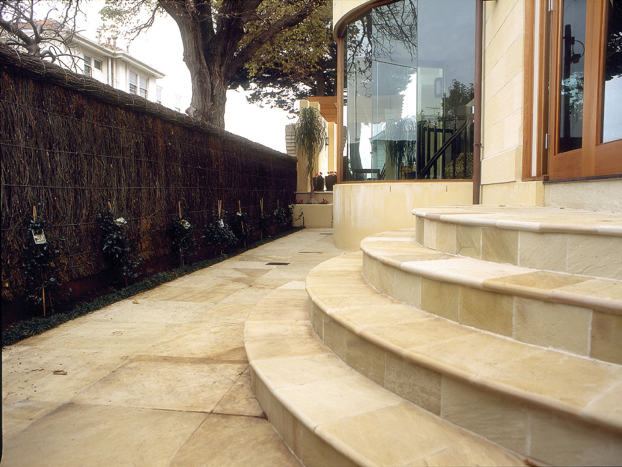 Exterior steps to house using sandstone pavers, curved architecture, walkway, wall, orange