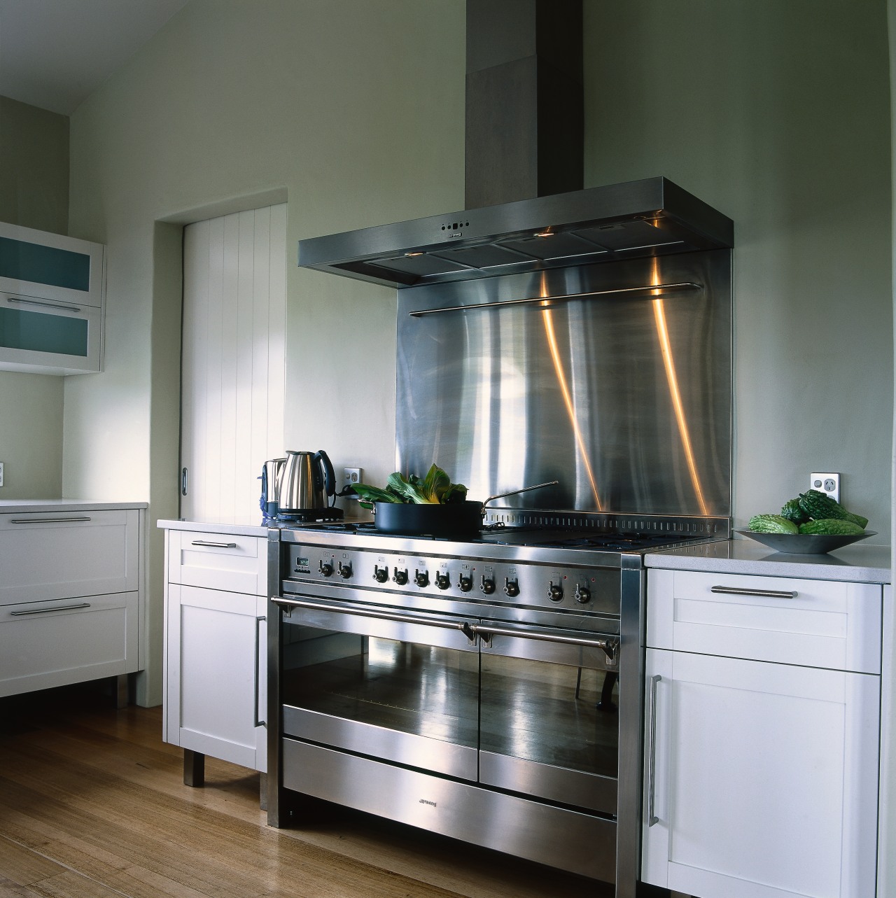 Kitchen with white cabinetry, timber flooring and large cabinetry, countertop, cuisine classique, gas stove, home appliance, interior design, kitchen, kitchen appliance, kitchen stove, major appliance, refrigerator, gray, black