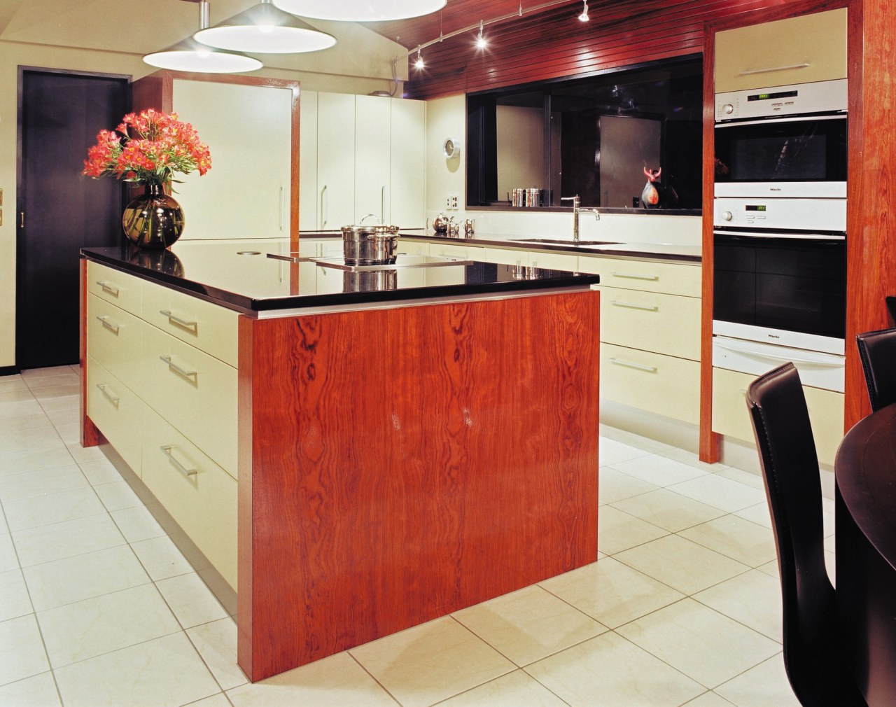 Contemporary kitchen with black granite benchtops, rosewood veneer cabinetry, countertop, cuisine classique, floor, flooring, furniture, interior design, kitchen, room, red, white