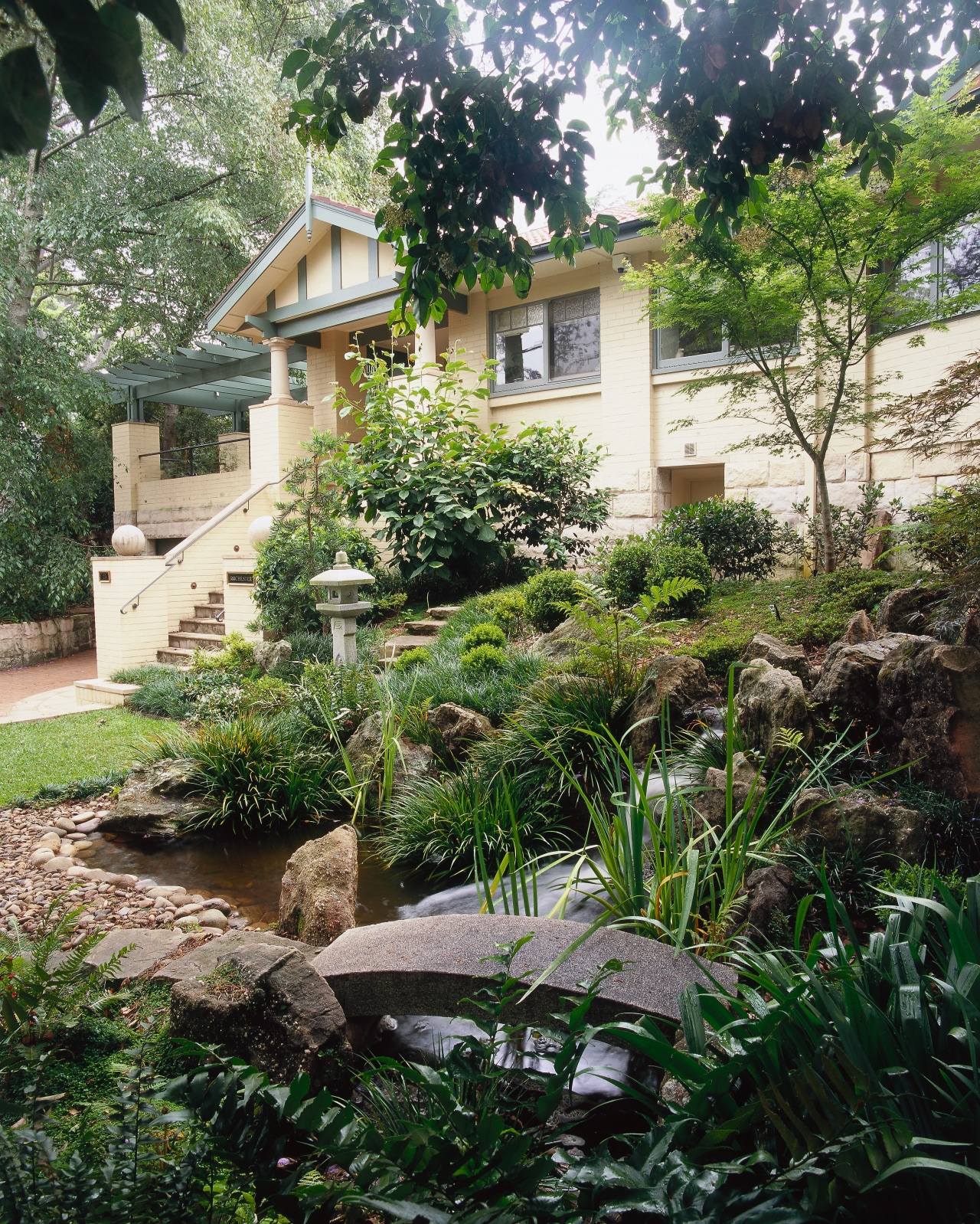 Exterior view of the house, many plants. backyard, cottage, courtyard, estate, garden, home, house, landscape, landscaping, outdoor structure, plant, property, real estate, tree, walkway, yard, green