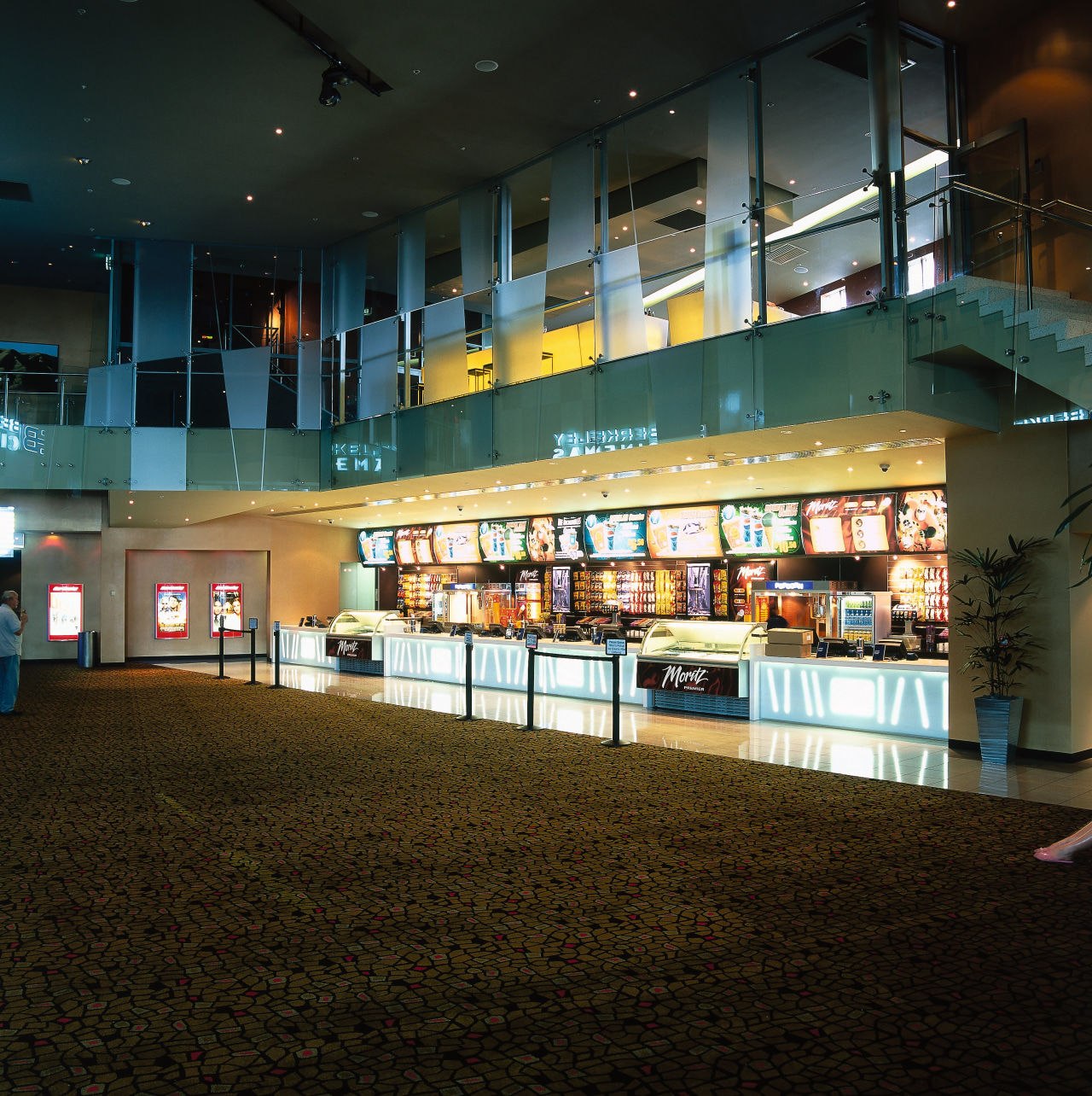 Retail shop area of cinema complex with bright architecture, metropolitan area, night, reflection, shopping mall, black