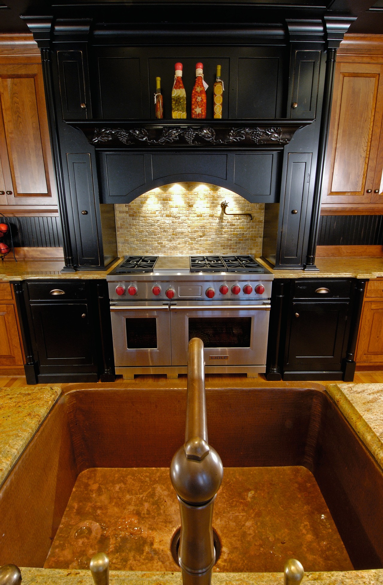 View of the cooking area, black cabinetry, stainless cabinetry, countertop, floor, flooring, hardwood, interior design, kitchen, room, under cabinet lighting, brown, black