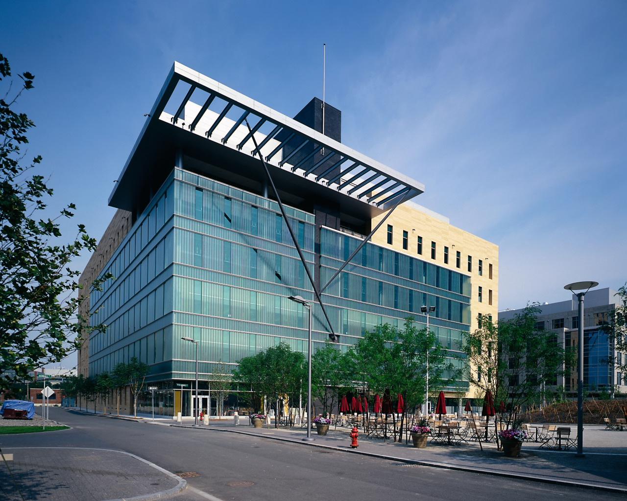 View of a large concrete, steel and glass architecture, building, city, commercial building, condominium, corporate headquarters, daytime, downtown, facade, headquarters, metropolis, metropolitan area, mixed use, real estate, residential area, sky, tower block, teal