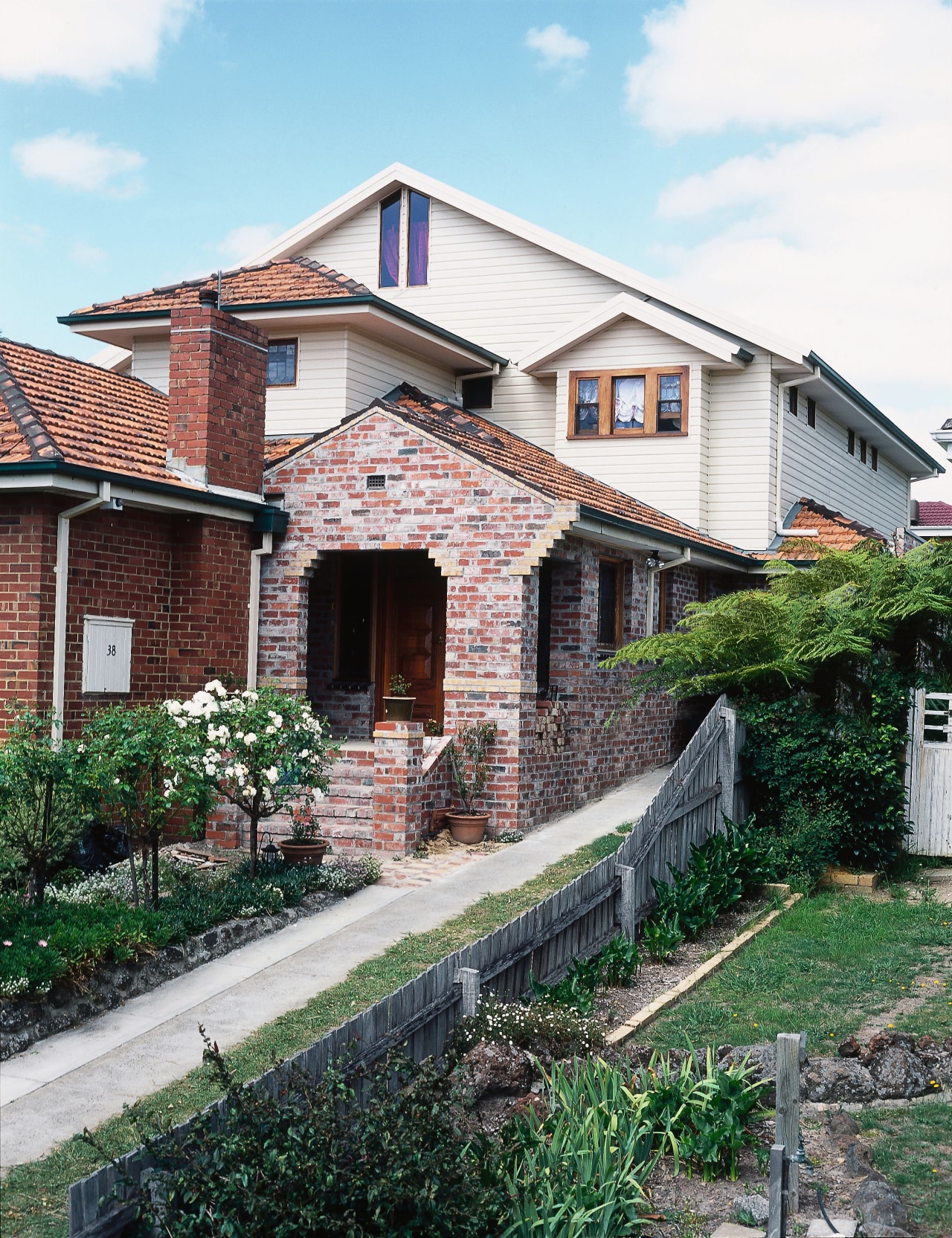 Exterior of home with brick cladding in front building, cottage, estate, facade, home, house, neighbourhood, property, real estate, residential area, roof, siding, suburb, villa, window, white