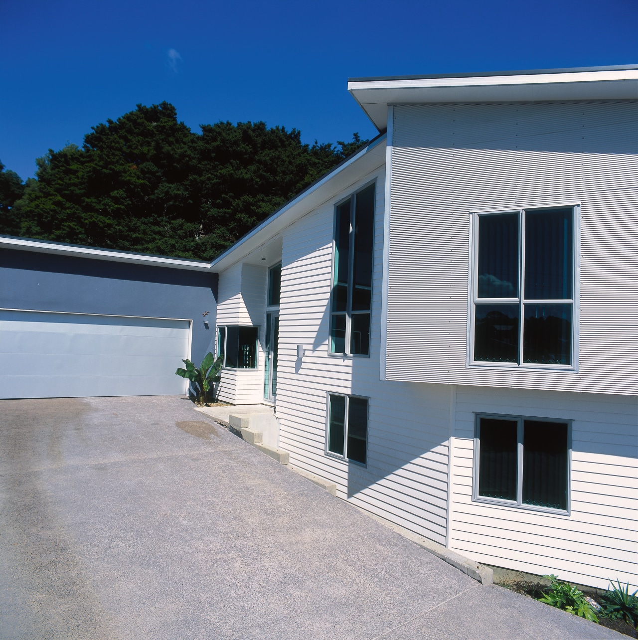 Exterior of home with cream weatherboards, driveway and architecture, building, cottage, facade, home, house, property, real estate, residential area, siding, sky, window, gray