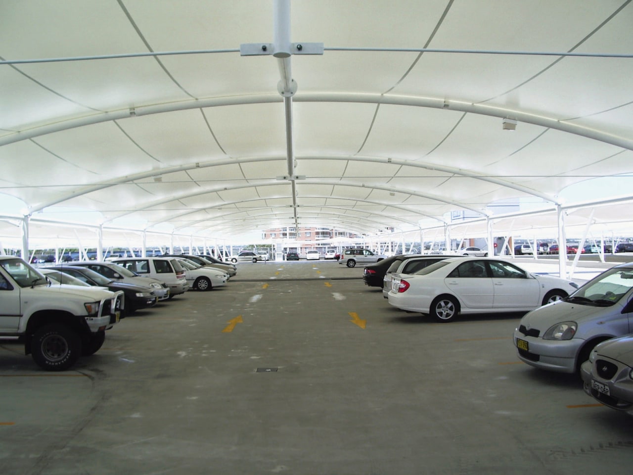 view of the all weather membrane car park airport terminal, building, car, hangar, luxury vehicle, motor vehicle, parking, parking lot, structure, gray