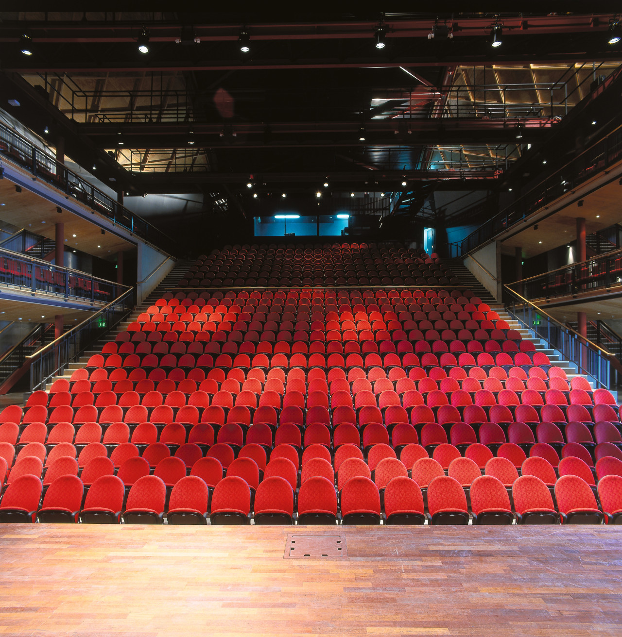 Large theatre arena with red seats and timber arena, audience, auditorium, concert hall, performing arts center, sport venue, stage, structure, theatre, black, red