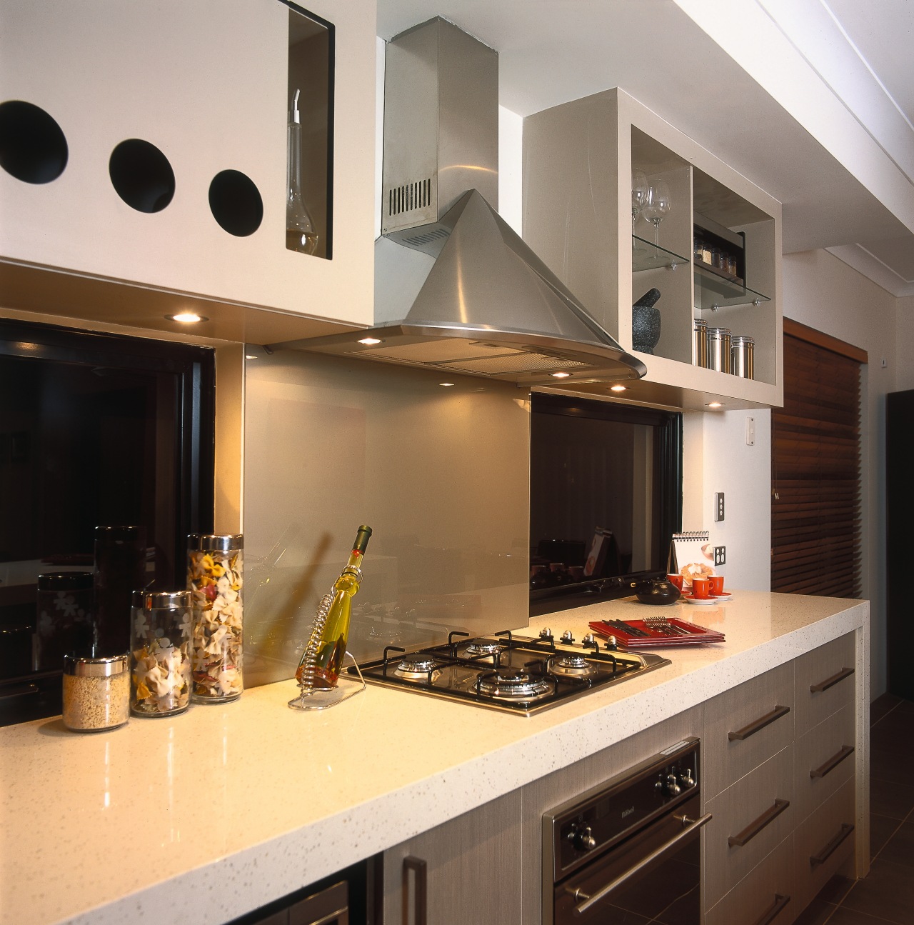 A view of a kitchen, wooden flooring, cream countertop, cuisine classique, interior design, kitchen, room, under cabinet lighting, gray, black