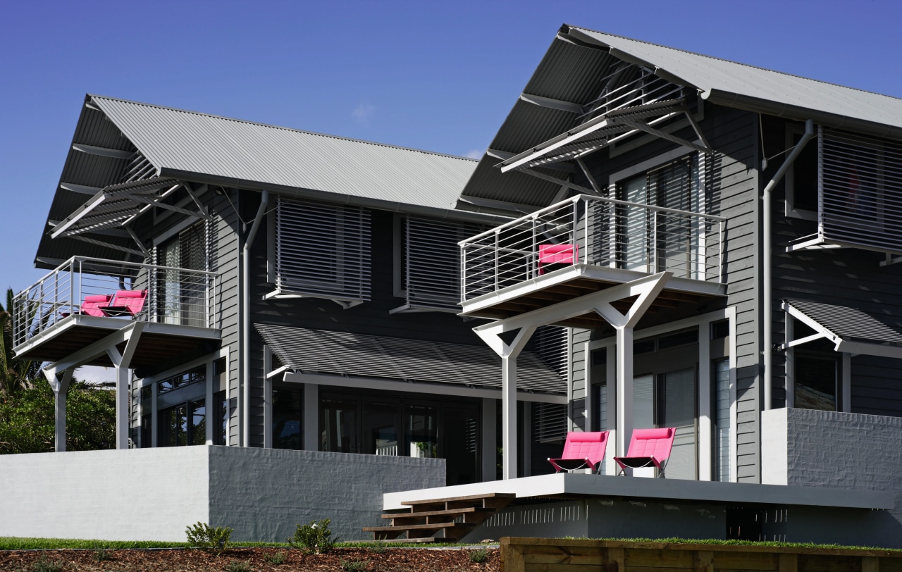 An exterior view of a large grey wooden architecture, building, elevation, facade, home, house, property, real estate, residential area, roof, siding, structure, window, black