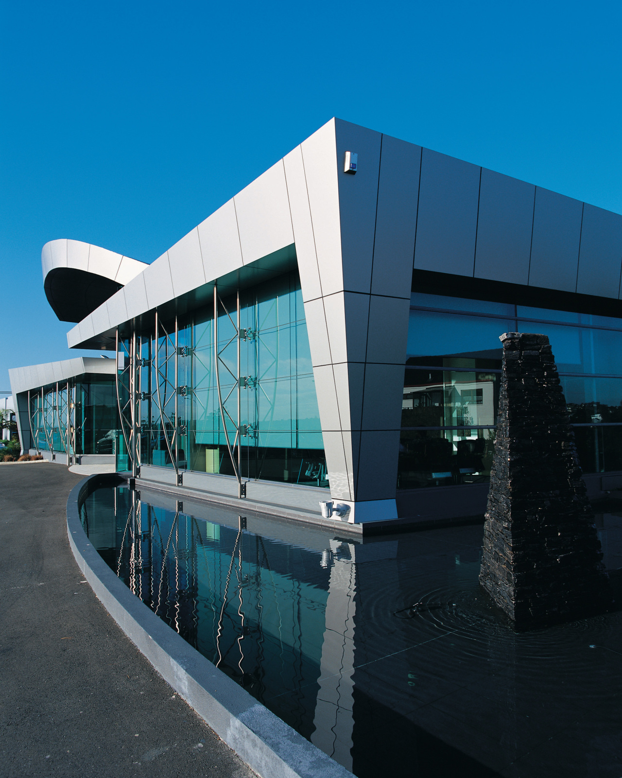 Exterior view of building showing large windows and architecture, building, commercial building, corporate headquarters, facade, headquarters, metropolitan area, reflection, sky, structure, black, teal