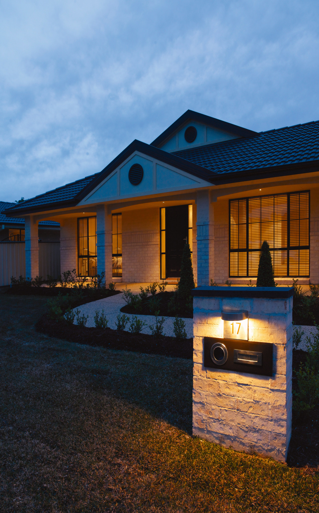 Front exterior entranceway of home, showing night lighting. architecture, building, cloud, cottage, estate, evening, facade, home, house, lighting, real estate, reflection, residential area, roof, siding, sky, window, black, teal