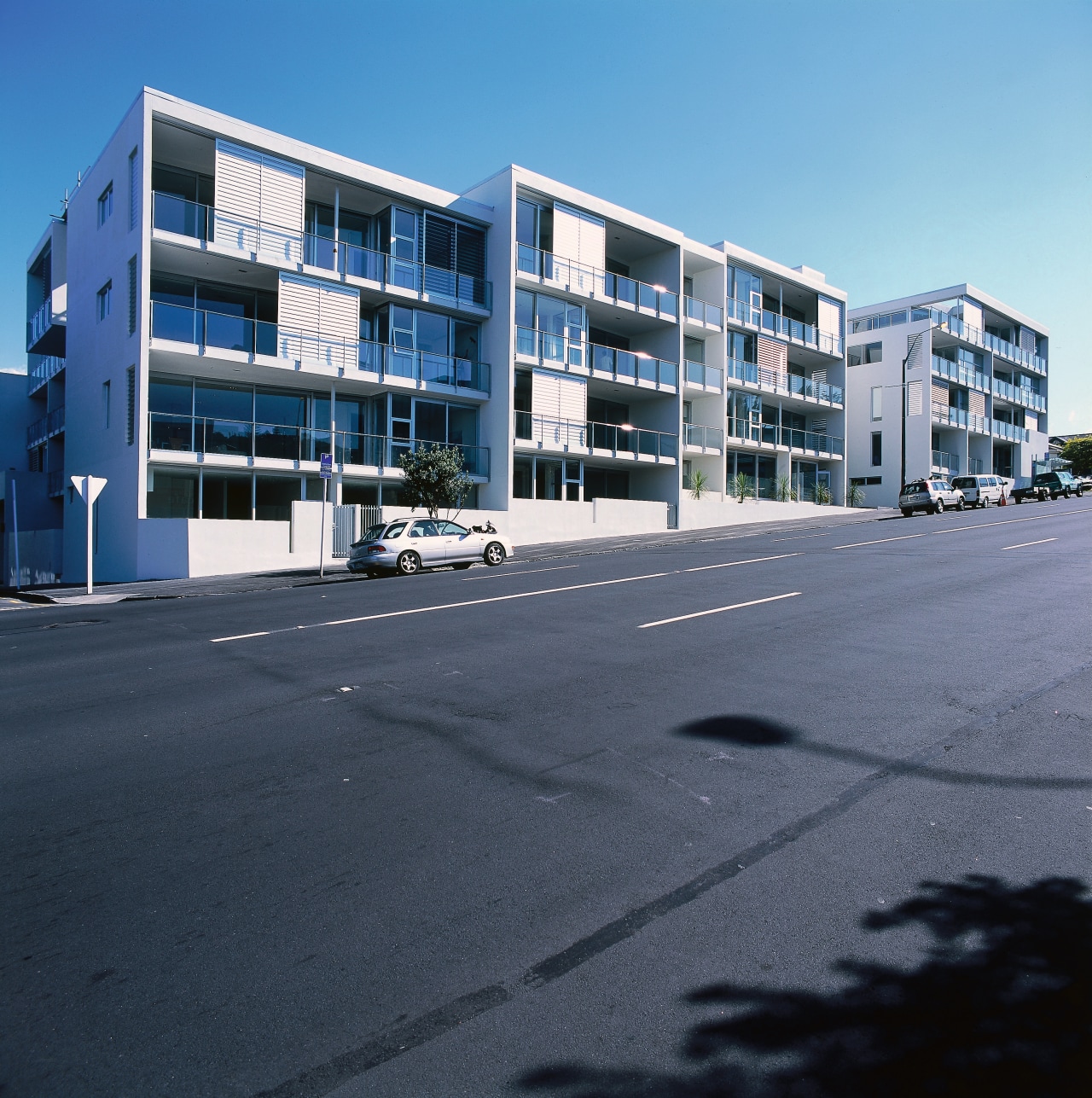 An exterior view of some apartments. apartment, architecture, building, commercial building, condominium, corporate headquarters, estate, facade, family car, home, house, metropolitan area, mixed use, neighbourhood, property, real estate, residential area, sky, suburb, window, black