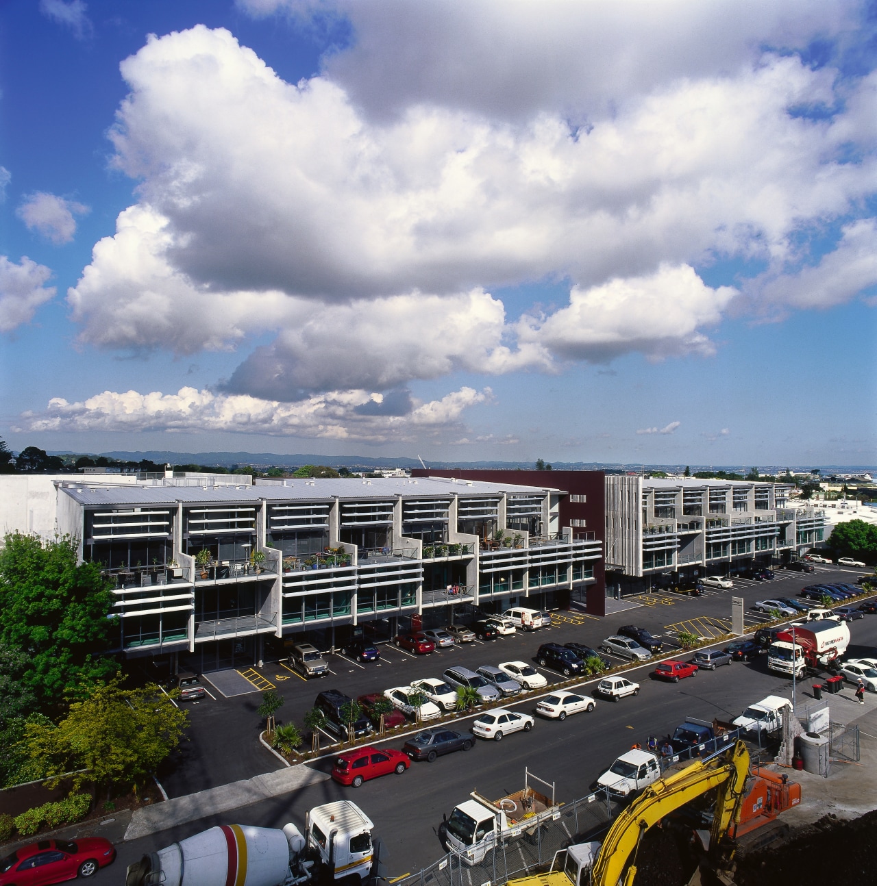 A view of the entire complex. building, car, city, cloud, daytime, metropolis, metropolitan area, mixed use, parking lot, plant, real estate, residential area, road, sky, suburb, tree, urban area, gray, black