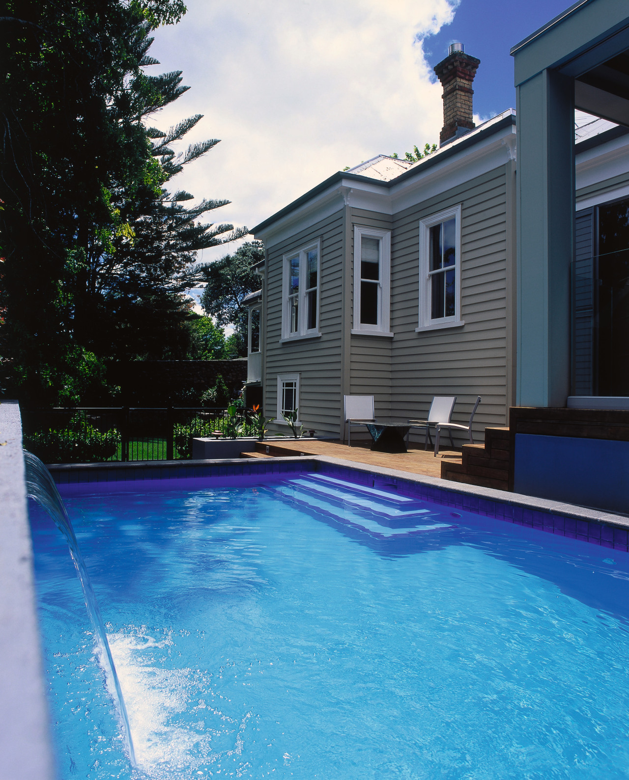 Images of a pool with a water feature, backyard, estate, home, house, outdoor structure, property, real estate, reflection, residential area, siding, sky, swimming pool, villa, water, teal, black