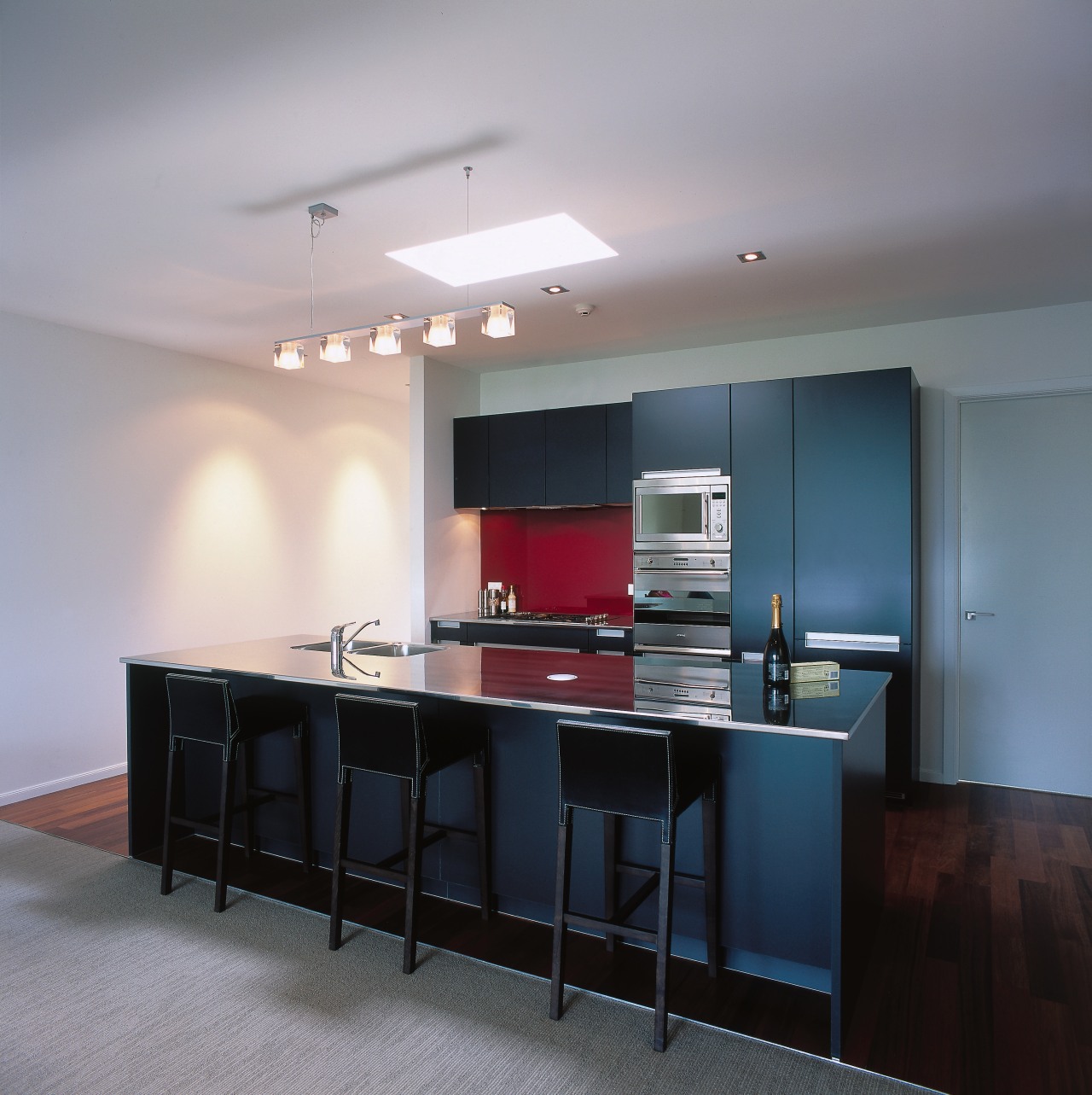 Apartment kitchen with blue cabinetry, stainless steel benchtop ceiling, countertop, floor, interior design, kitchen, real estate, room, table, gray, black