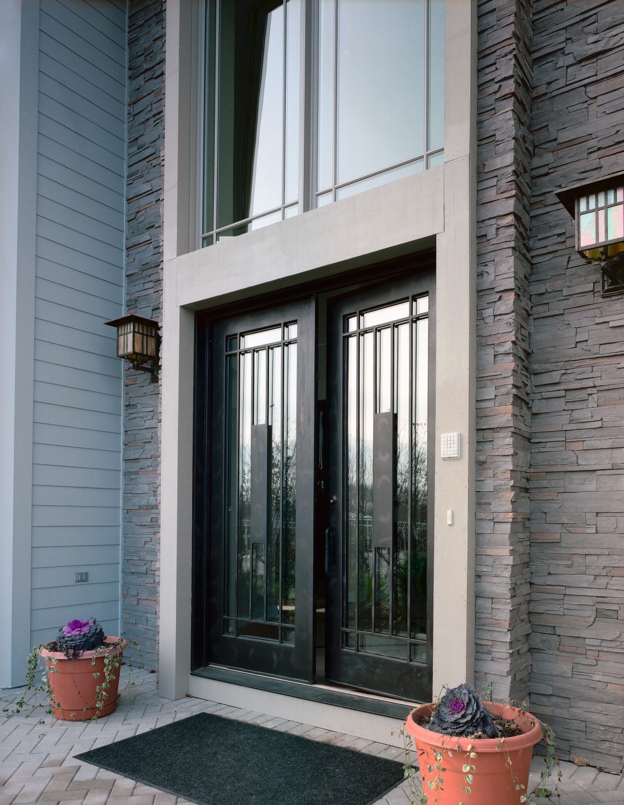 Exterior view of apartment entranceway showing glass and door, facade, home, house, porch, real estate, sash window, siding, window, gray, black