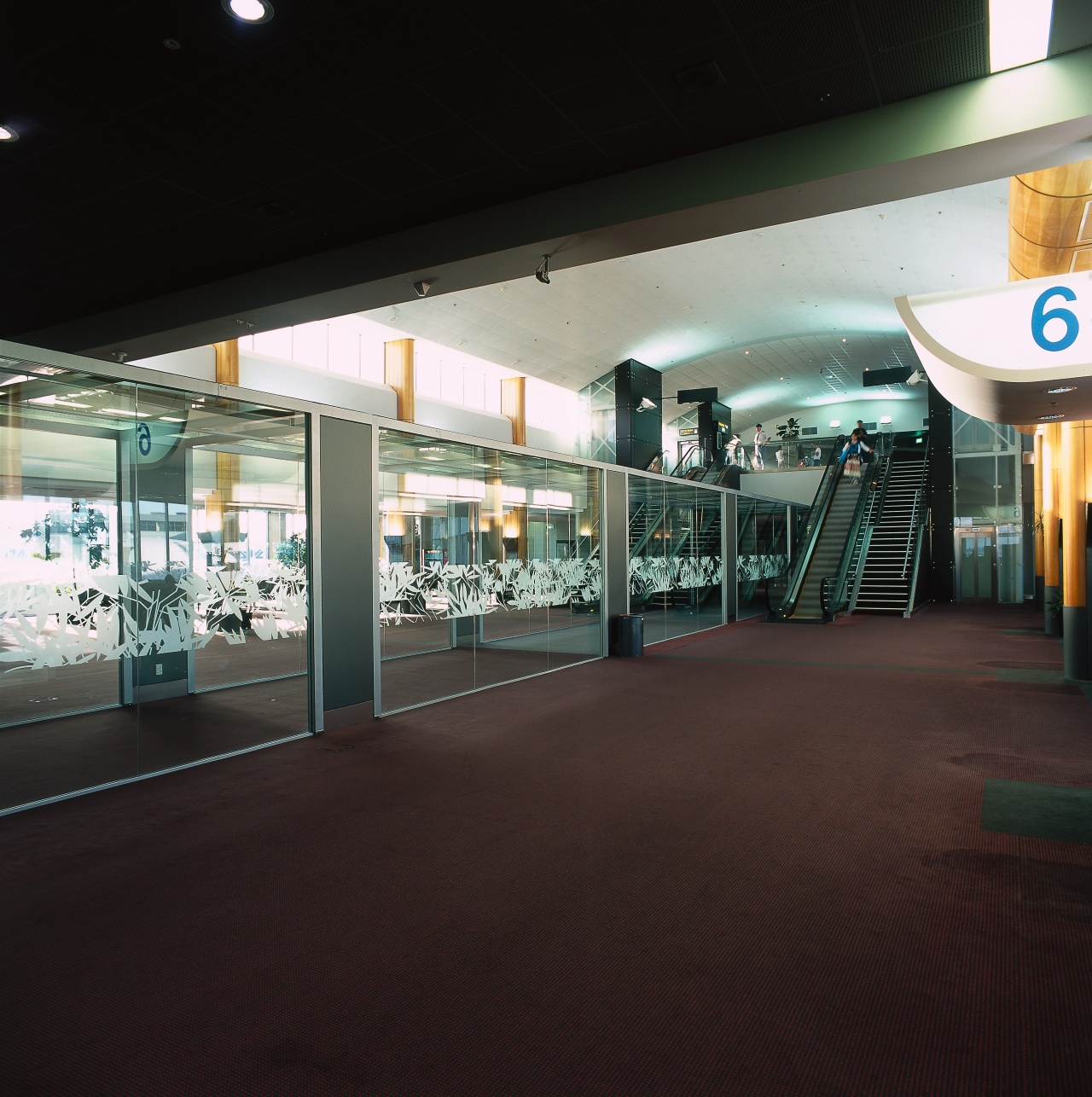 Fully glazed walkway next to stair and escalator. airport terminal, metropolitan area, black