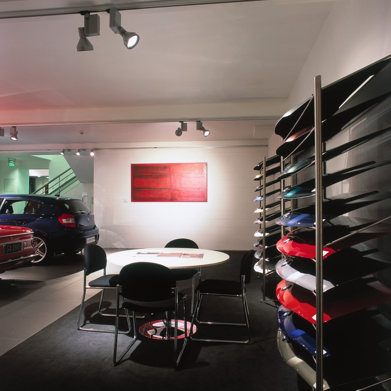 BMW showroom with white walls, shelving for parts ceiling, interior design, gray, black