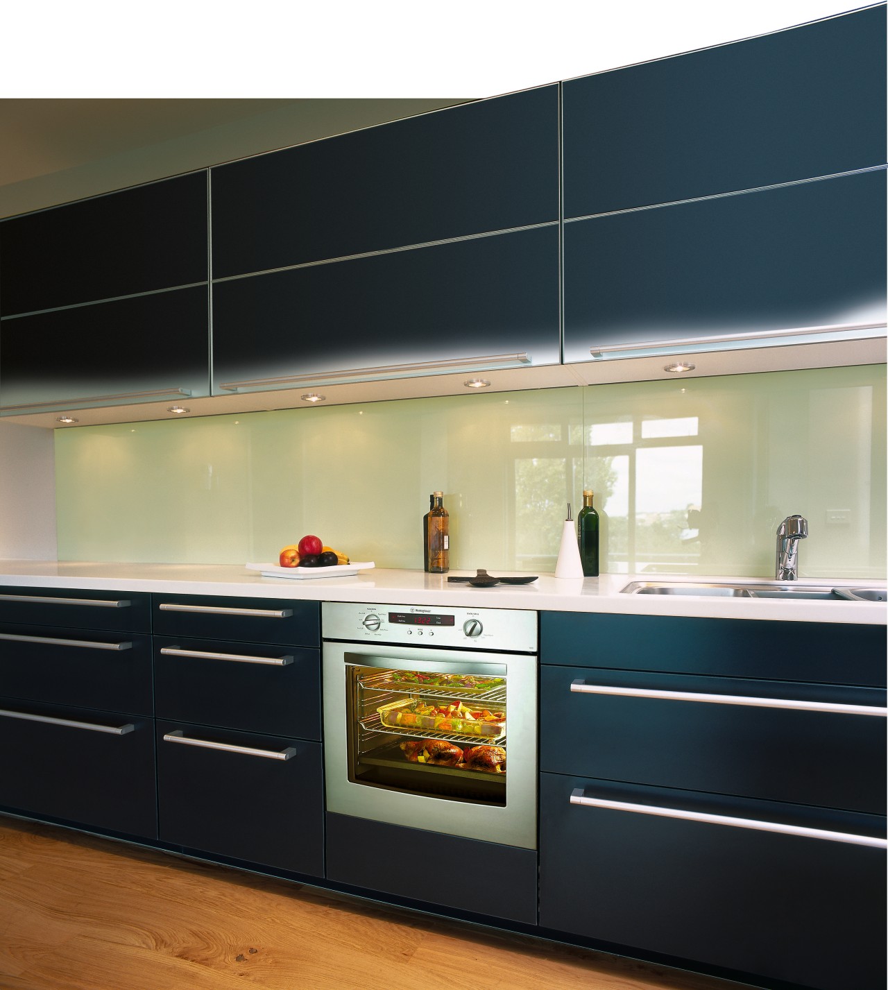 Kitchen with black cabinetry, long handles, green splashback cabinetry, countertop, home appliance, interior design, kitchen, kitchen stove, major appliance, under cabinet lighting, black