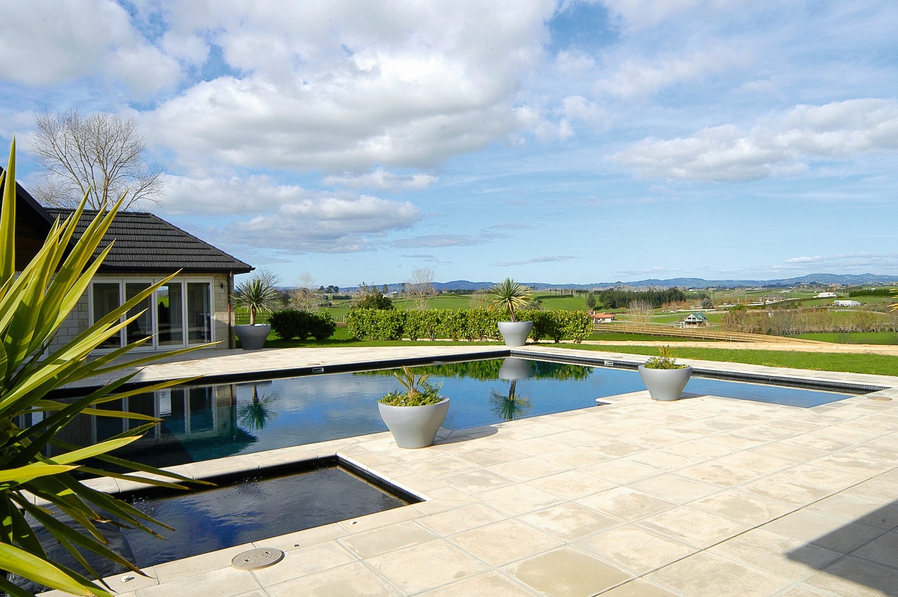 Outdoor pool with sandstone coloured pavers. cloud, estate, home, house, leisure, property, real estate, reflection, residential area, resort, sky, swimming pool, tree, villa, water, white