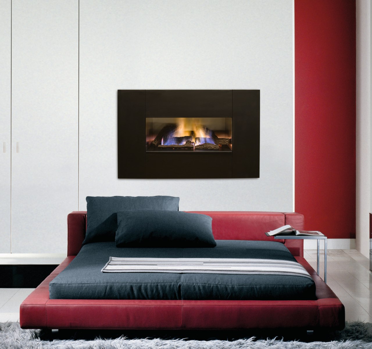 Fireplace with dark surround set into white wall, bed, bed frame, couch, fireplace, furniture, hearth, interior design, mattress, sofa bed, white