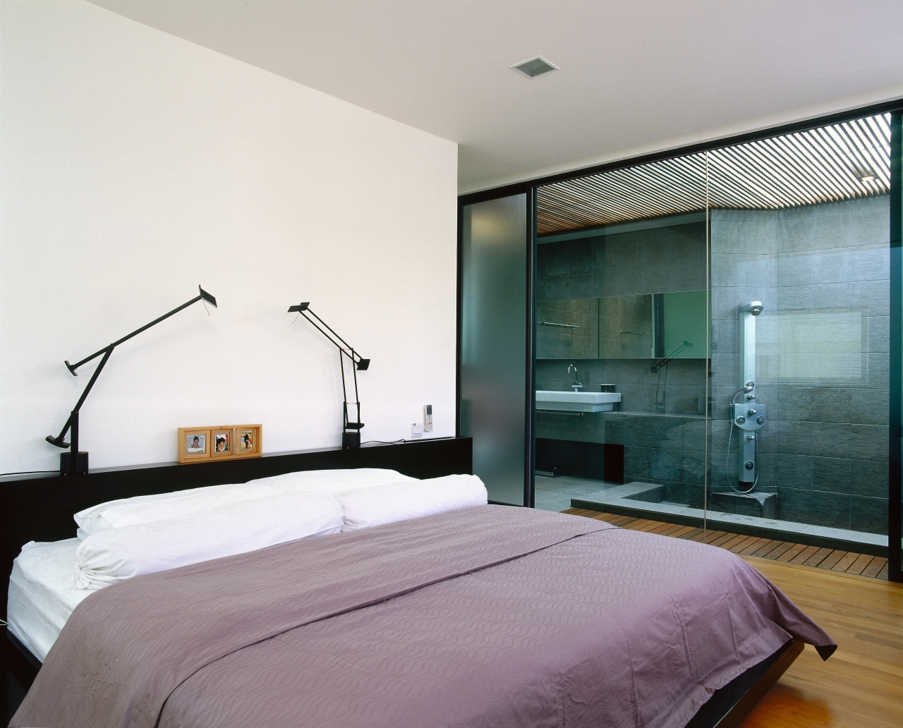 view of this master bedroom featuring timber flooring architecture, bed frame, bedroom, ceiling, interior design, real estate, room, suite, wall, white, gray