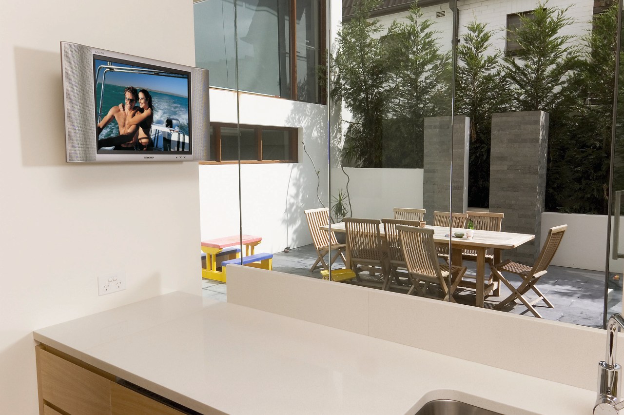 Kitchen with white benchtop, wall mounted tv screen, countertop, furniture, interior design, product design, table, white