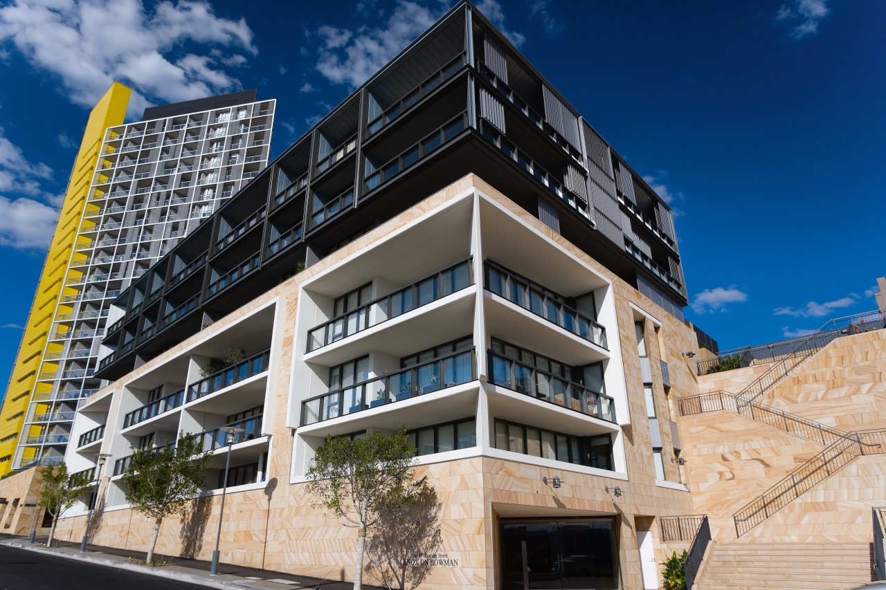 An exterior view of the apartments. apartment, architecture, building, commercial building, condominium, corporate headquarters, elevation, facade, home, mixed use, property, real estate, residential area, blue