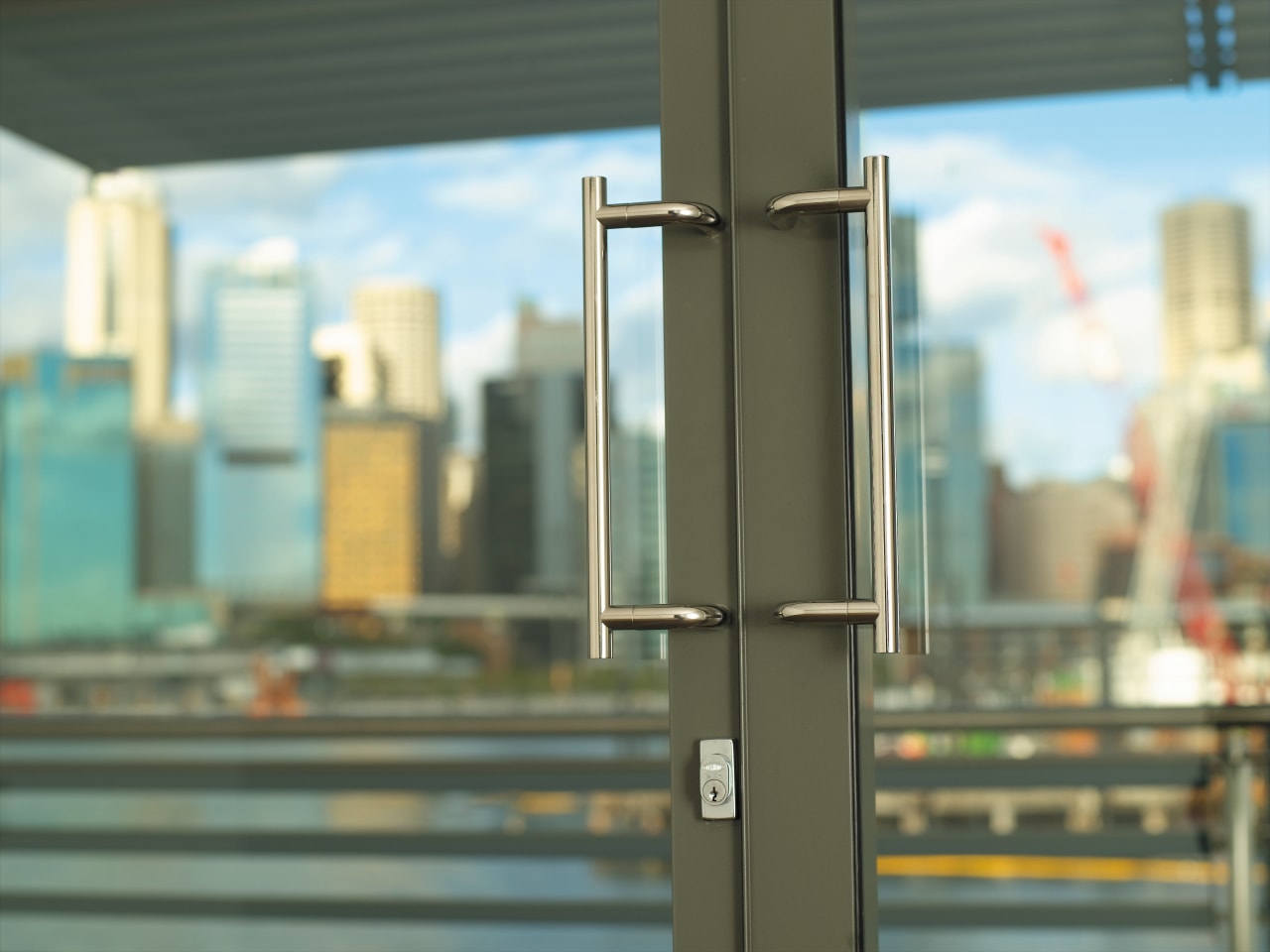 view of the lobby featuring door hardware by glass, metropolitan area, window, gray, brown