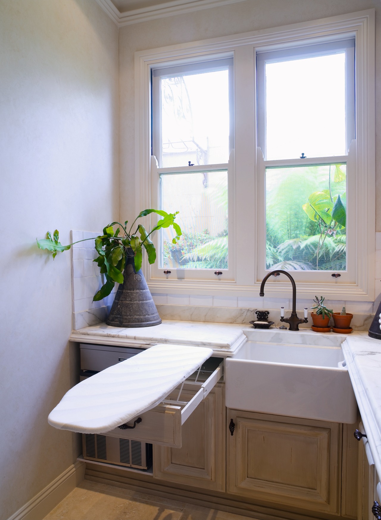 Interior view of laundry featuring fold-away ironing board bathroom, countertop, daylighting, home, house, interior design, kitchen, room, sink, window, gray