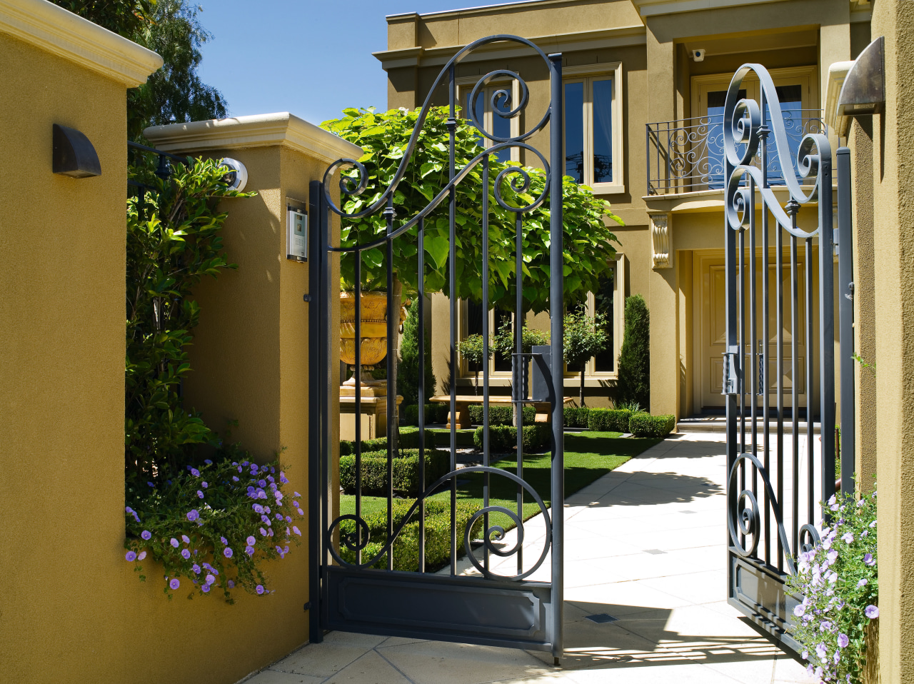 A view of this Mediteranean style house courtyard, estate, facade, fence, gate, home, house, neighbourhood, outdoor structure, property, real estate, residential area, brown