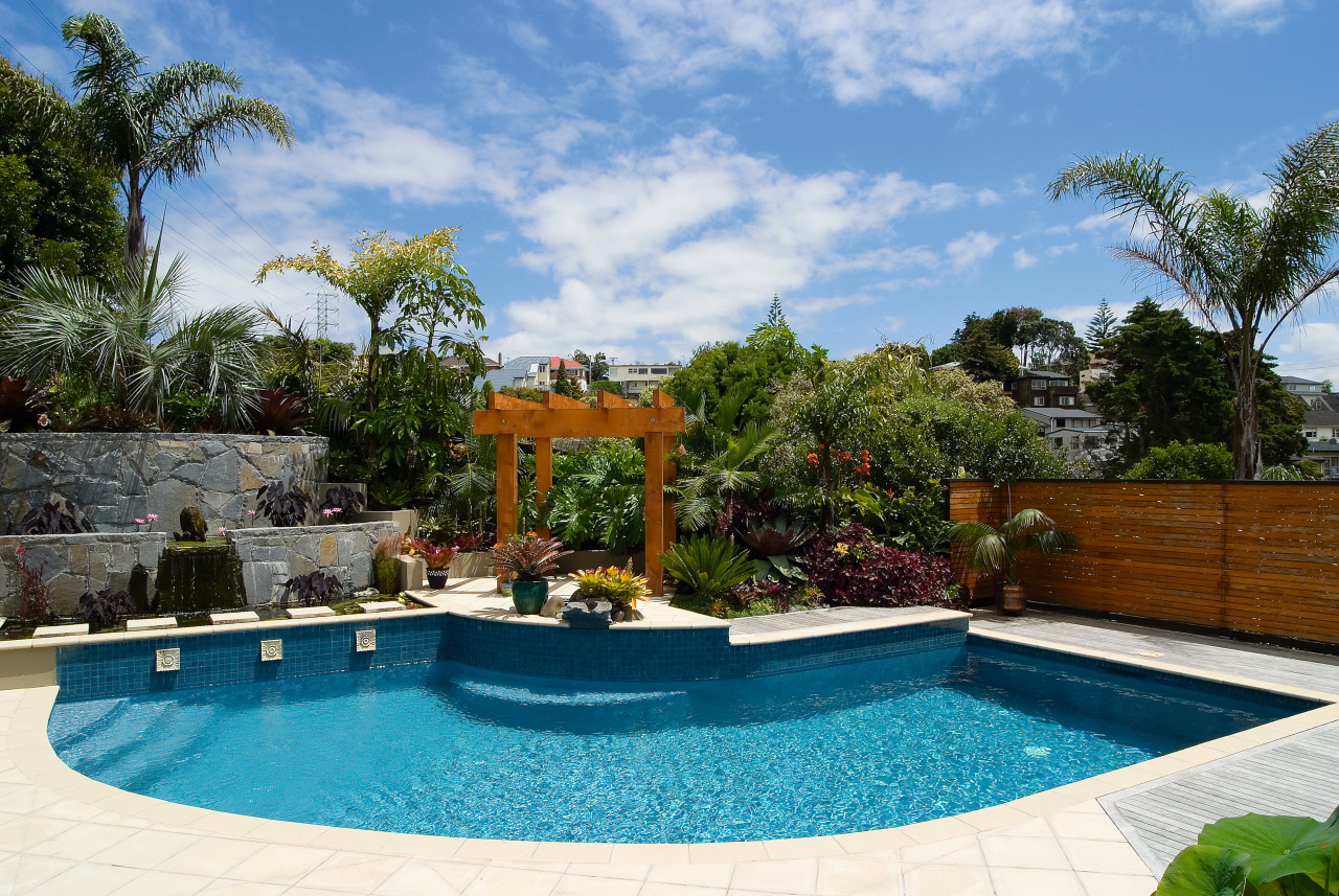 A view of this pool designed and installed arecales, backyard, estate, home, landscaping, leisure, outdoor structure, palm tree, property, real estate, resort, swimming pool, tree, villa, water feature, teal