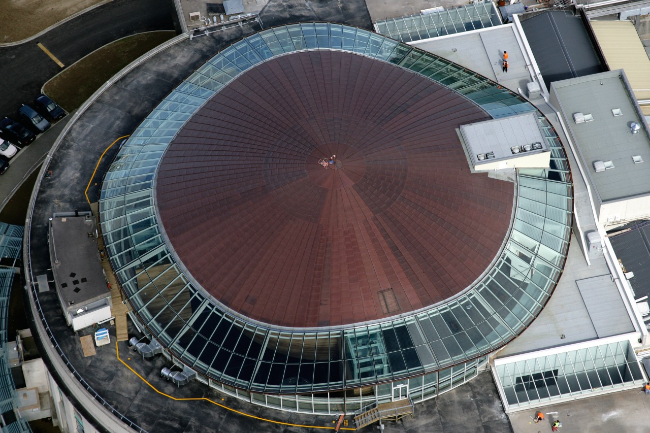 View of the oval copper and glass roof aerial photography, arena, bird's eye view, building, daylighting, sport venue, stadium, structure, urban area, black, gray