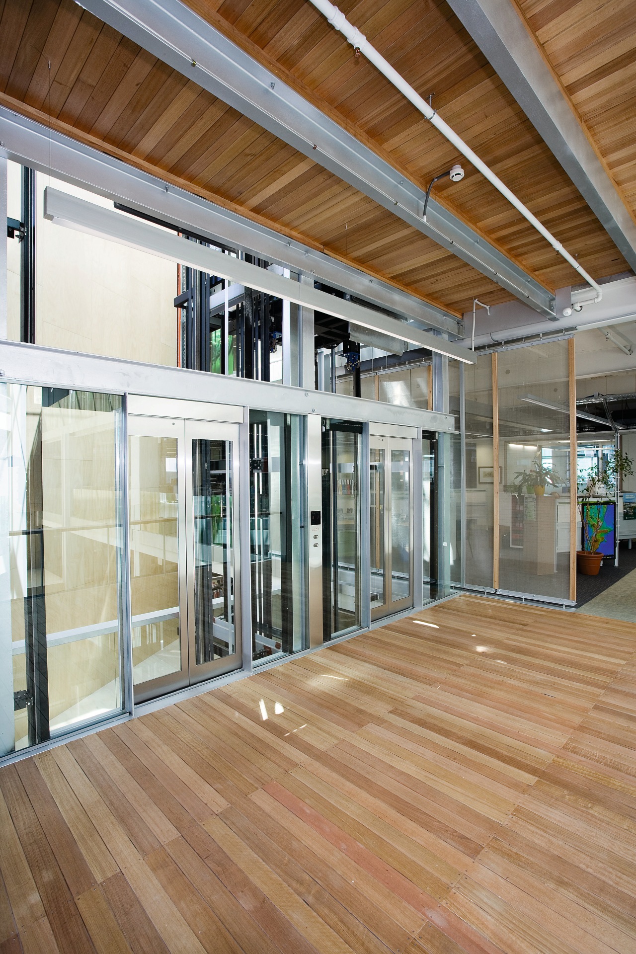 A view of the interior space of the architecture, ceiling, daylighting, door, facade, floor, flooring, glass, hardwood, house, interior design, laminate flooring, lobby, real estate, window, wood, wood flooring, brown, gray