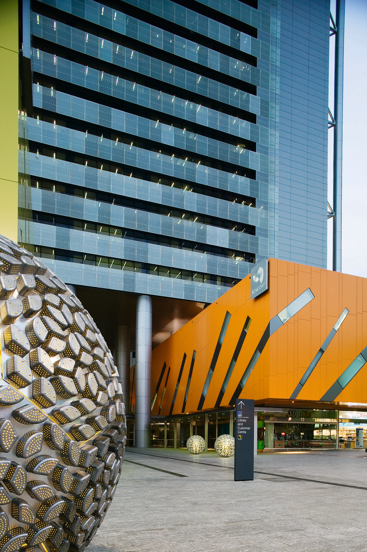 View of Brisbane square featuring bright colours, sculptured architecture, building, condominium, facade, metropolitan area, skyscraper, tower block, urban area, yellow, teal