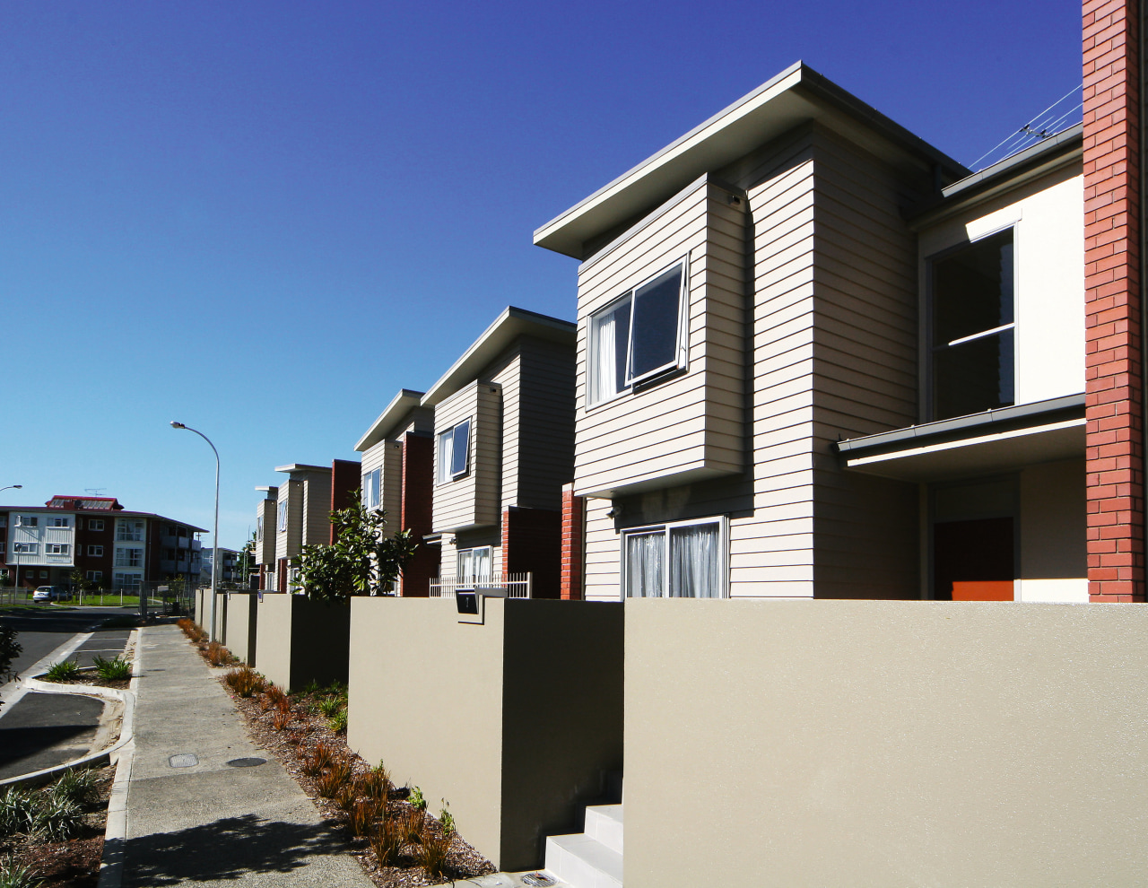 An exterior view of this new residential complex apartment, architecture, building, condominium, elevation, facade, home, house, neighbourhood, property, real estate, residential area, siding, suburb, window, white, black