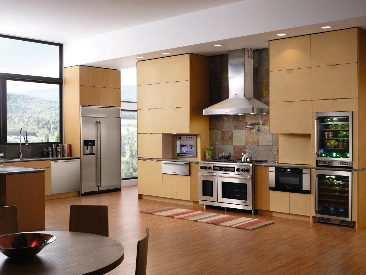 A view of this kitchen featuring timber veneer cabinetry, countertop, cuisine classique, floor, hardwood, home appliance, interior design, kitchen, living room, room, brown, gray