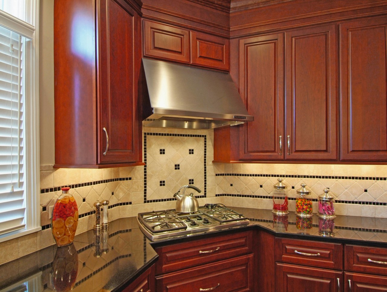 View of this kitchen designed and manufactured by cabinetry, countertop, cuisine classique, flooring, hardwood, home, interior design, kitchen, room, under cabinet lighting, wood stain, brown, red