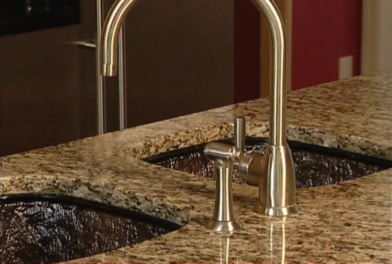 A view of this kitchen featuring a JSG countertop, plumbing fixture, sink, tap, brown