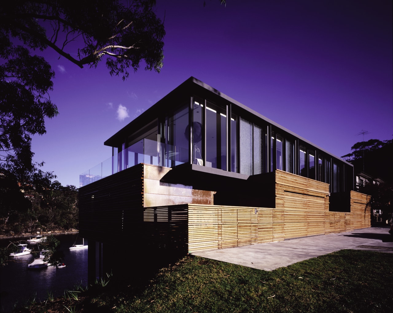 A view of a home developed by Sunland architecture, building, cottage, facade, home, house, lighting, night, real estate, residential area, sky, black, purple