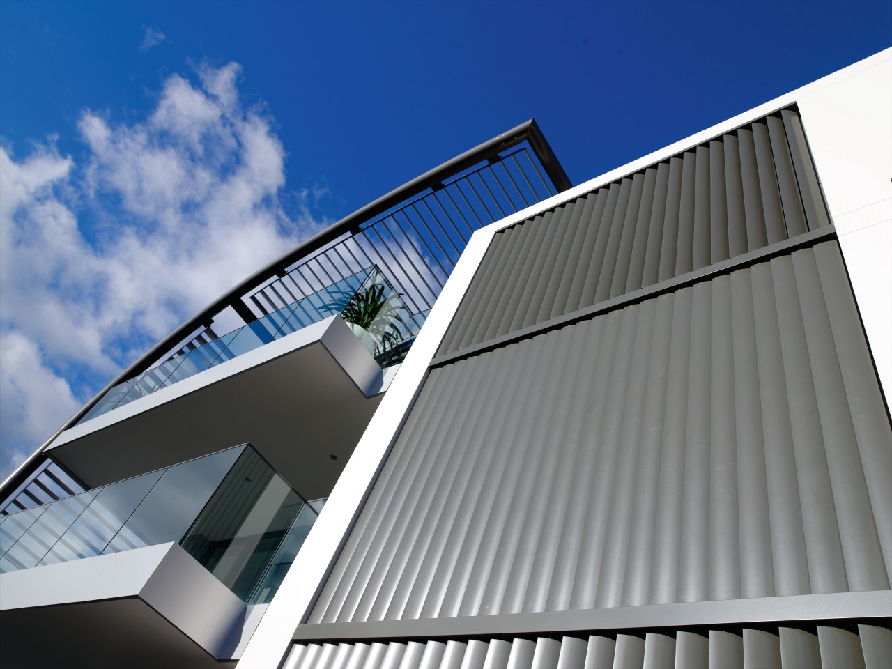 A view of this Apartment block featuring Louvres angle, architecture, building, commercial building, corporate headquarters, daylighting, daytime, elevation, facade, headquarters, house, line, roof, sky, structure, window, gray, blue