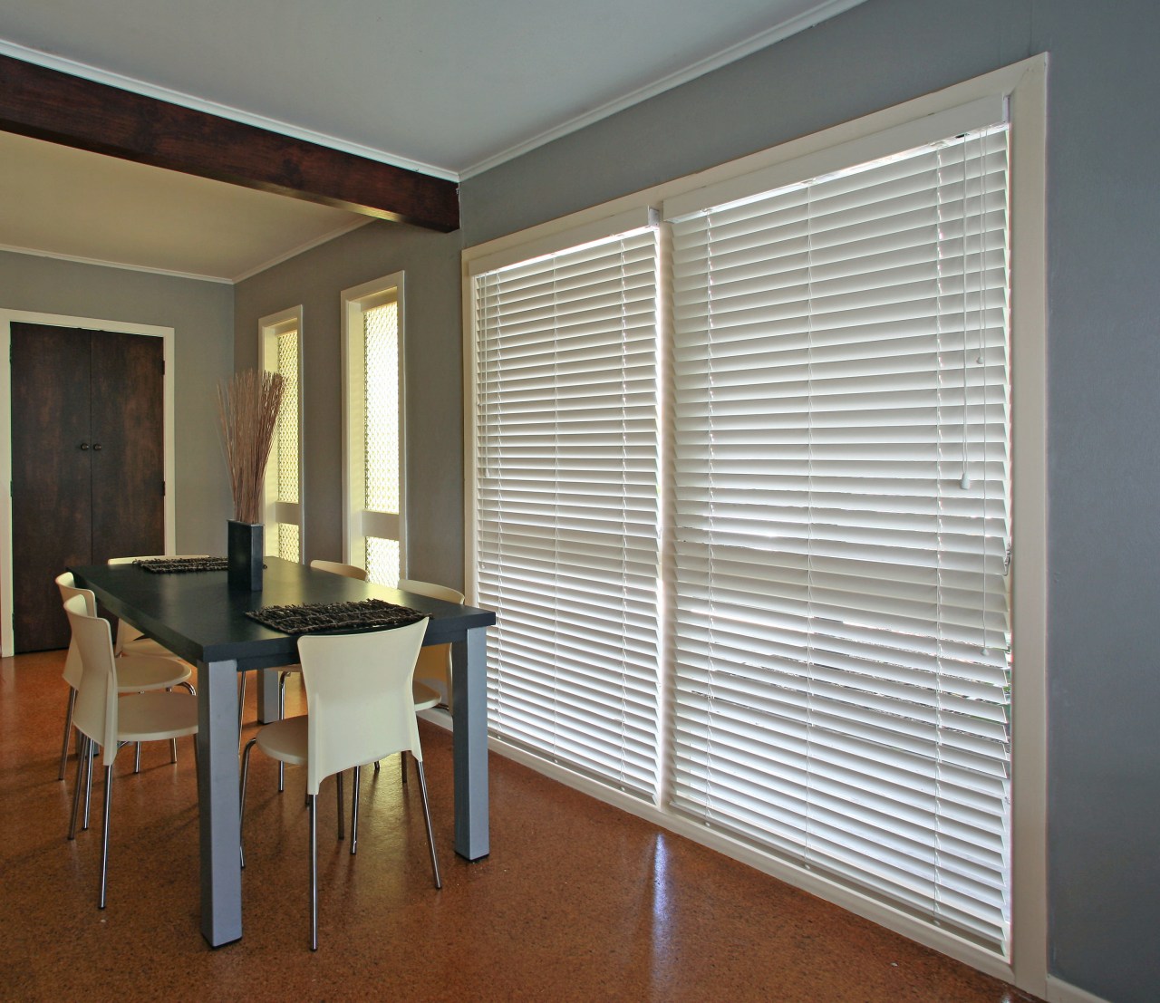 A view of this interior living space of door, floor, interior design, real estate, shade, window, window blind, window covering, window treatment, wood, gray, brown