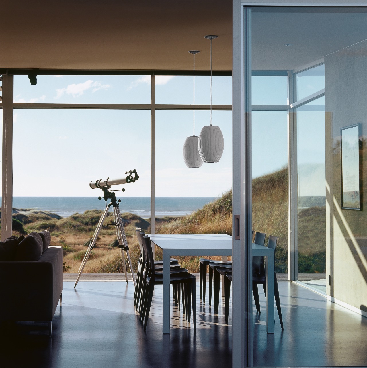 An interior view of the living area featuring architecture, door, glass, home, house, interior design, real estate, table, window, white