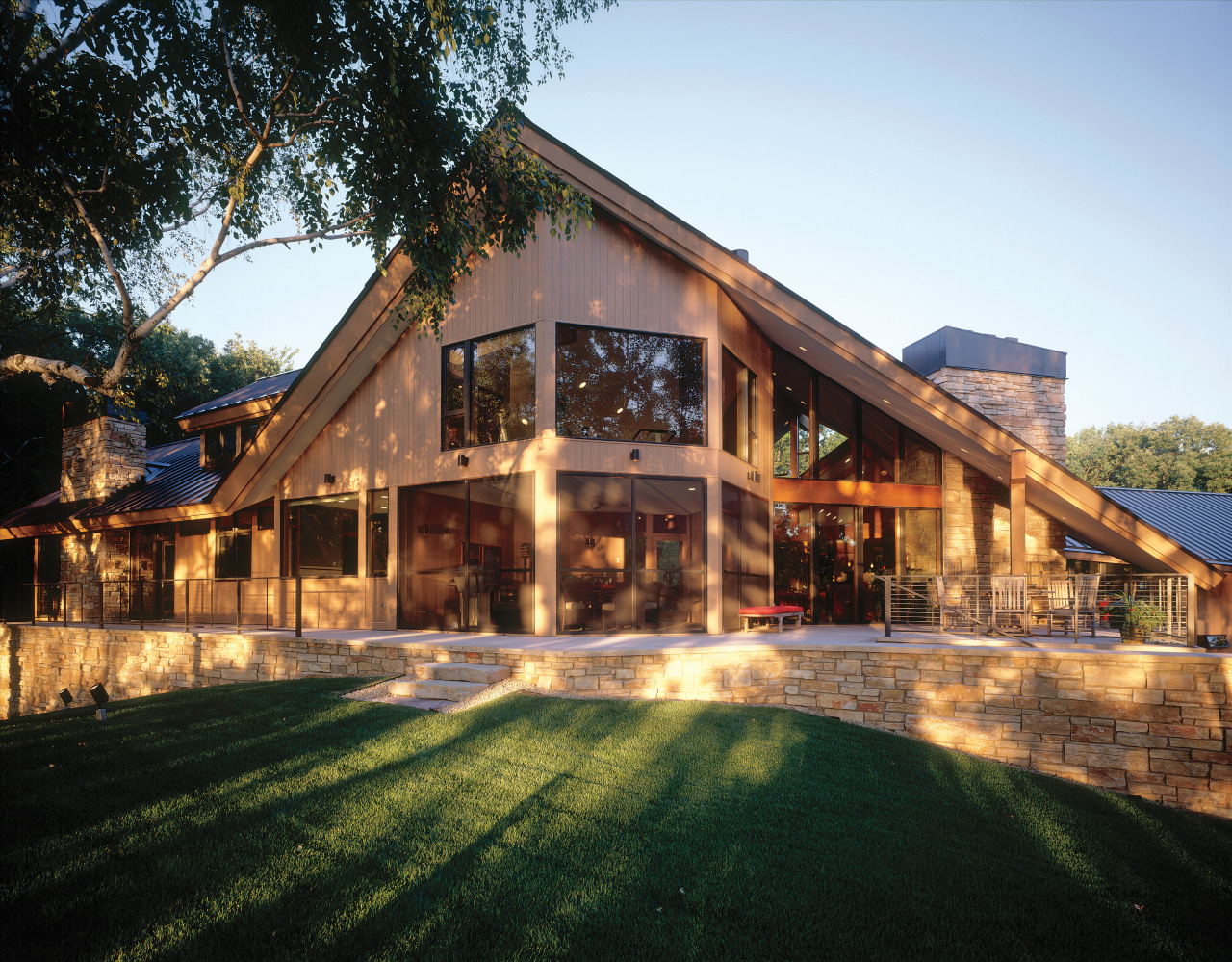 The roof visually archors the home to the cottage, estate, facade, farmhouse, home, house, landscape, lighting, mansion, property, real estate, residential area, roof, siding, black