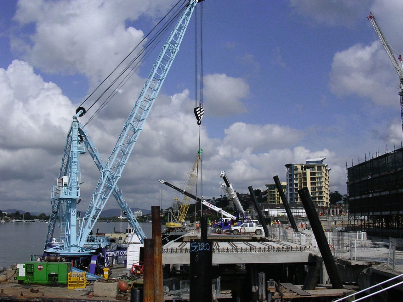 A view of the Portside Wharf  Waterway construction, construction equipment, crane, crane vessel floating, fixed link, port, gray, blue