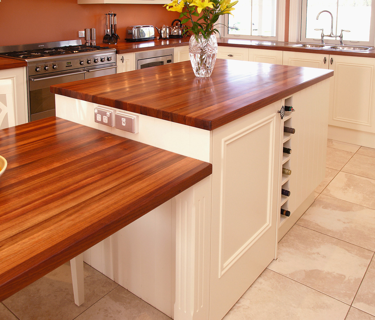 A view of this kitchen featuring blackwood timber cabinetry, countertop, cuisine classique, floor, flooring, furniture, hardwood, kitchen, laminate flooring, plywood, table, wood, wood flooring, wood stain, orange