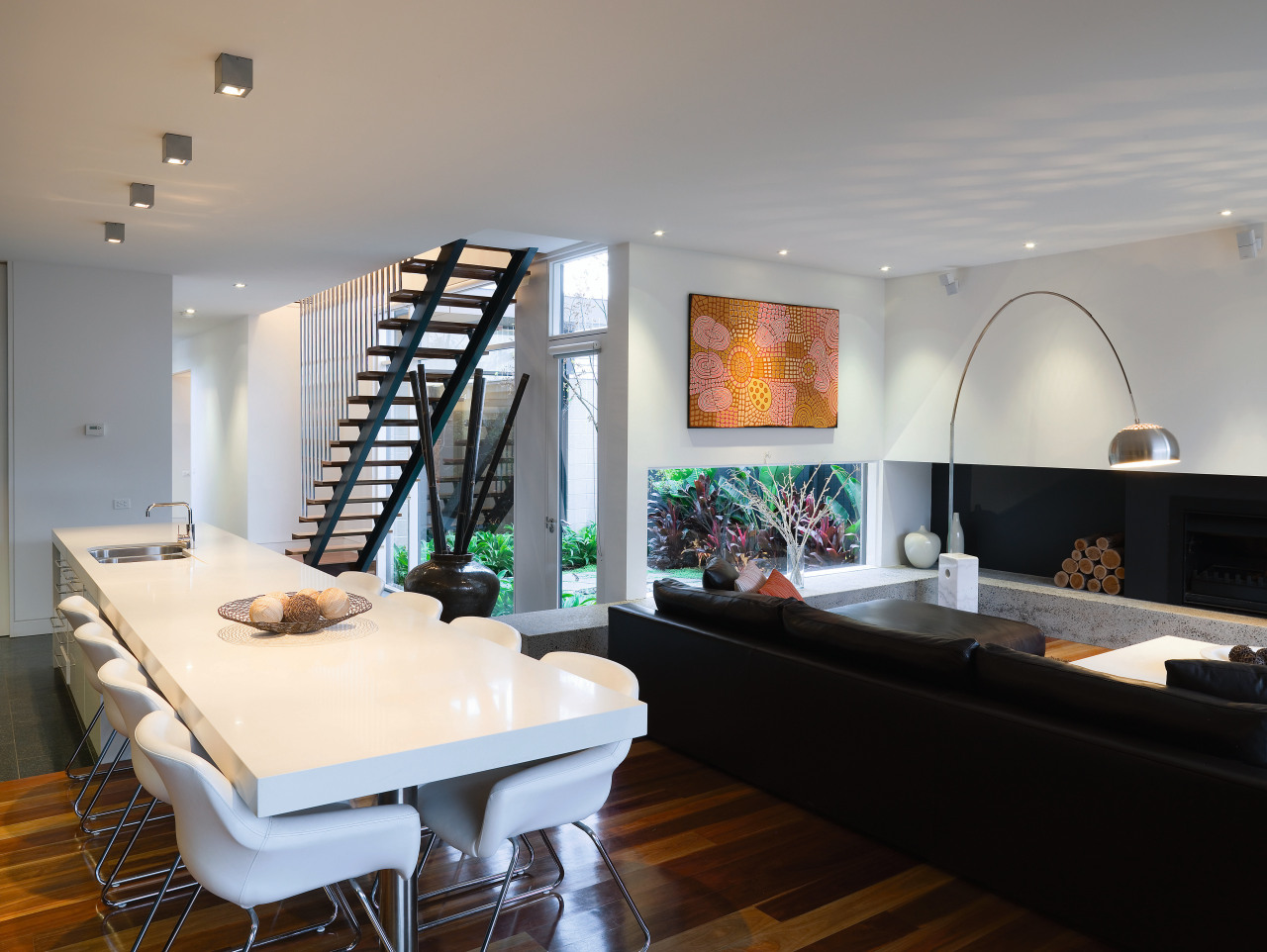 The open stairway adds a strong graphic element ceiling, interior design, living room, room, table, gray