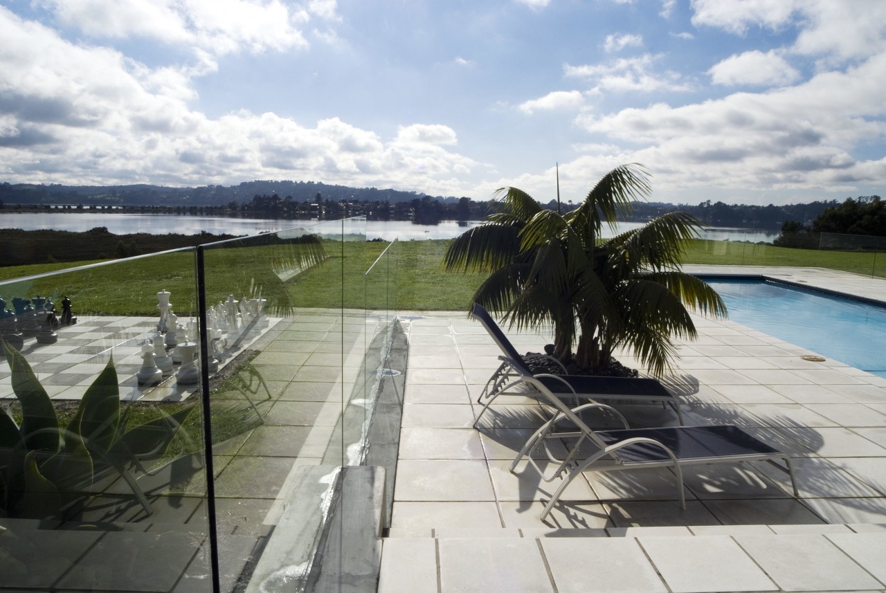 A view of this outdoor pool area featuring leisure, outdoor structure, property, real estate, sky, swimming pool, water, white