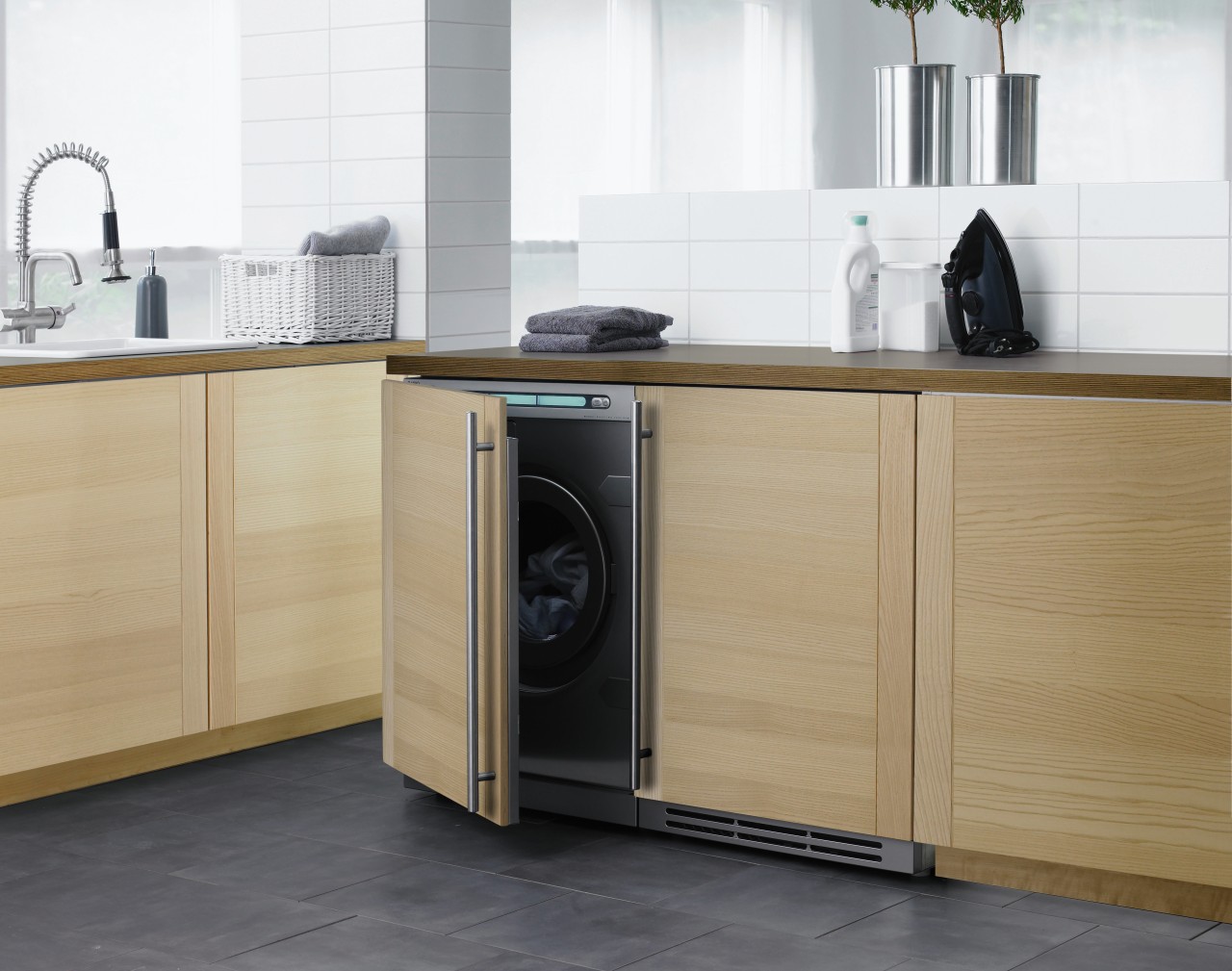 A view of this clean, contemporary laundry featuring cabinetry, clothes dryer, countertop, floor, furniture, home appliance, kitchen, kitchen appliance, kitchen stove, major appliance, product, product design, refrigerator, washing machine, white