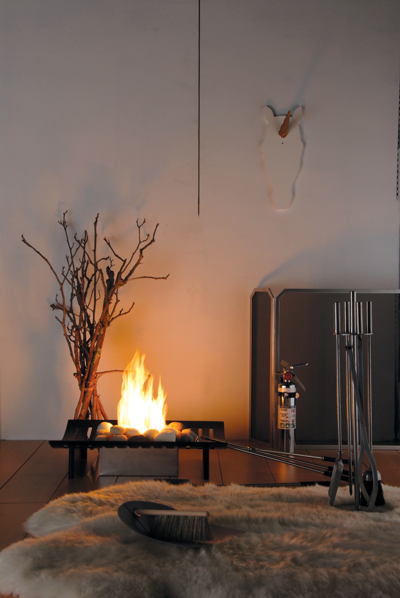 A view of a fireplace from Real Fires. ceiling, fireplace, hearth, heat, home, interior design, lamp, light fixture, lighting, lighting accessory, still life photography, table, wood, gray, black